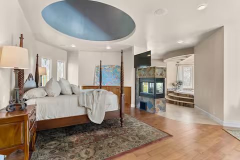 The domed primary suite with four-poster bed and fireplace