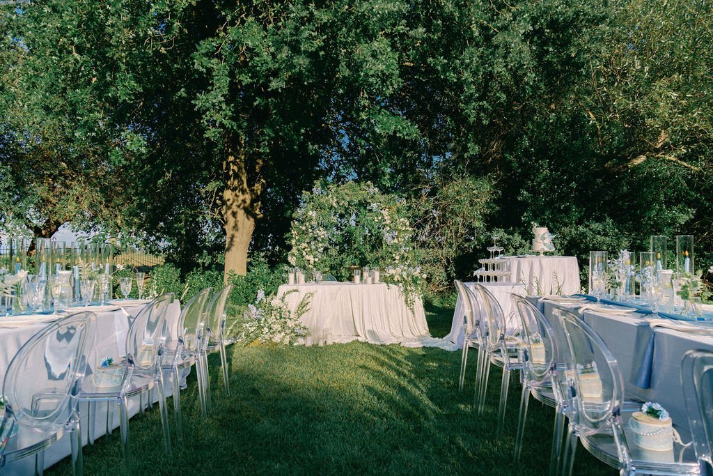 A reception laid out under the oaks at golden hour